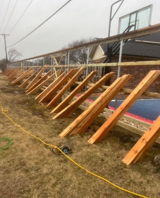 Cedar pickets staged along new fence rails during a long fence installation