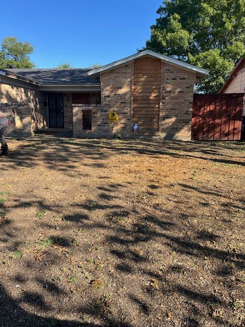 Cleared, raked front yard ready for new sod in front of a brick home