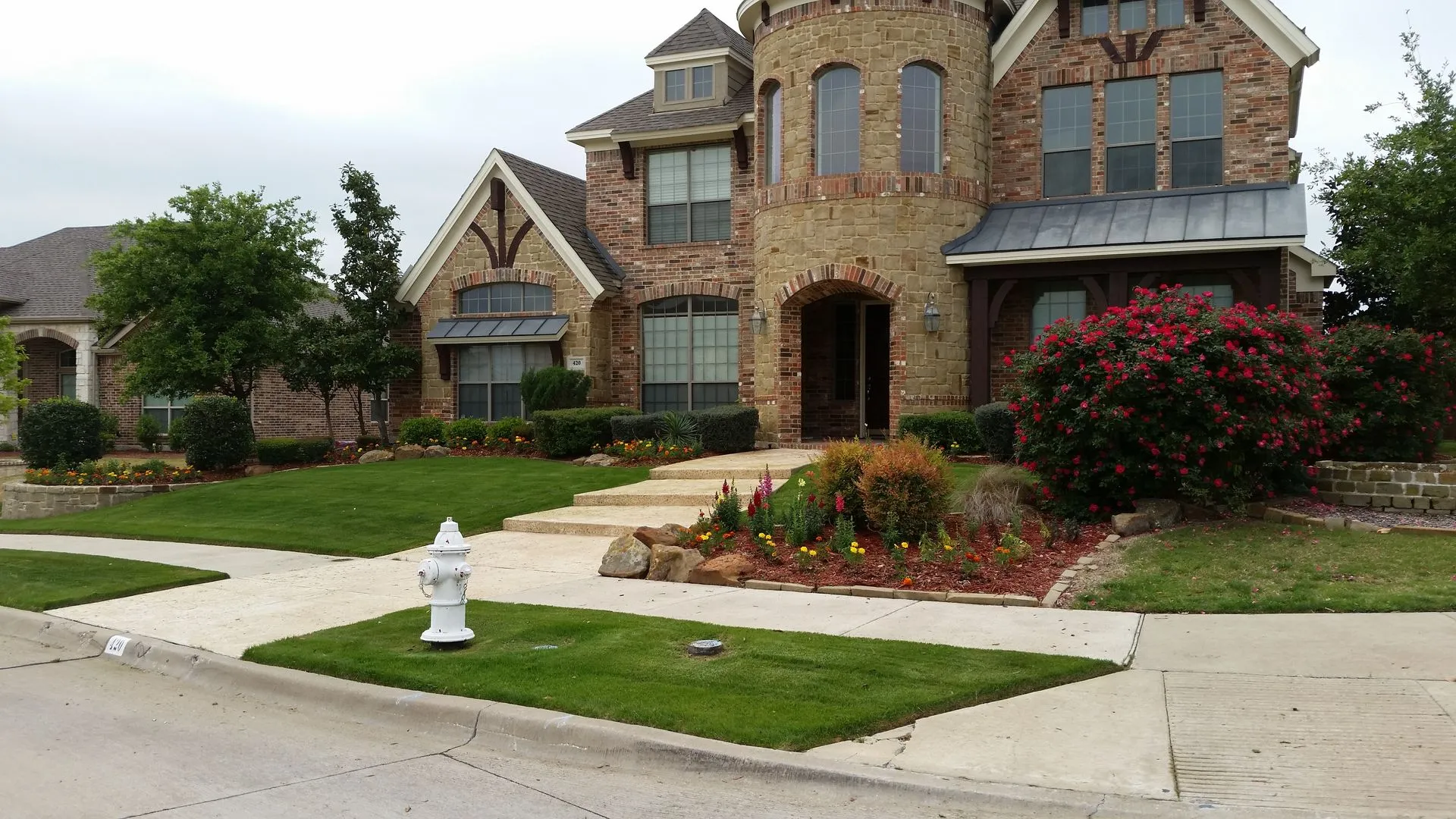 Front entry landscape with boulders, knockout roses and colorful perennials