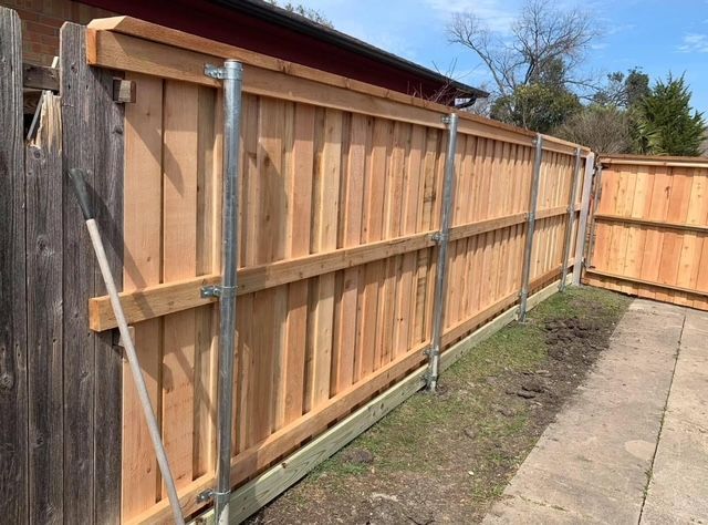 Cedar privacy fence built on galvanized steel posts along a sidewalk